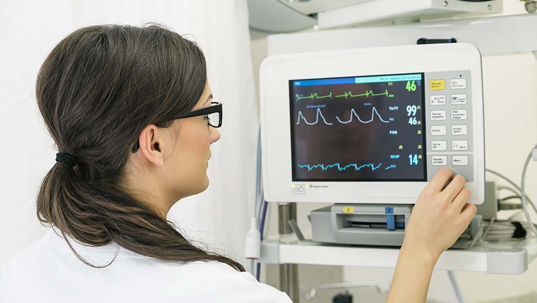 A lady doctor setting up a biomedical electric device.